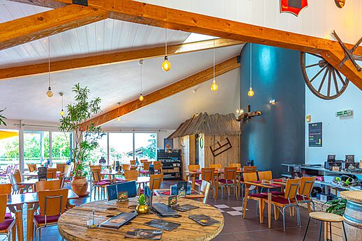 Interior del amplio restaurante con mesas y sillas en el camping VAGUES OCEANES Lac de Panthier en Vandenesse-en-Auxois (21).