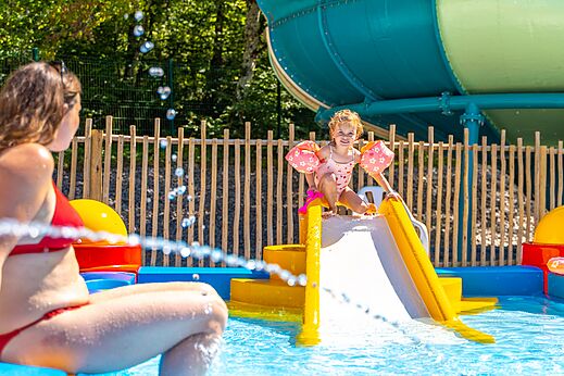 Ni�o en tobog�n acu�tico, piscina infantil en el camping VAGUES OCEANES Lac de Panthier en Vandenesse-en-Auxois (21).