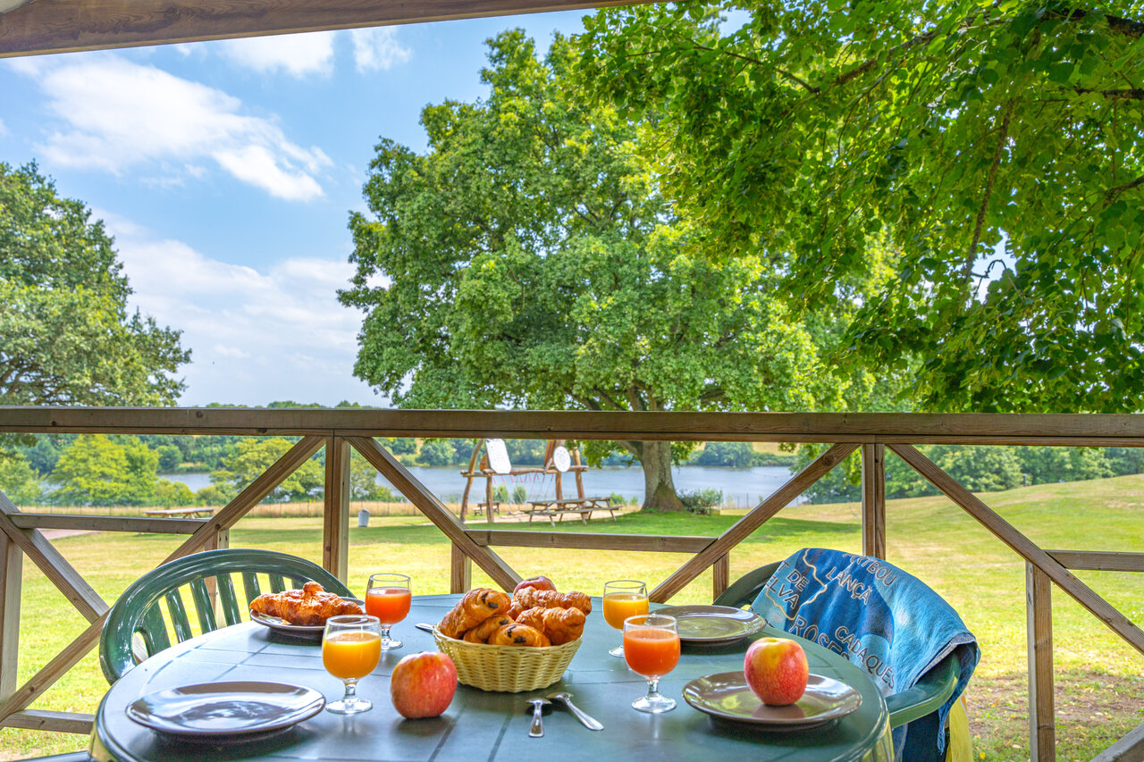Desayuno en terraza de alojamiento, vista al lago, en CAPFUN Lac de Ribou en Cholet.