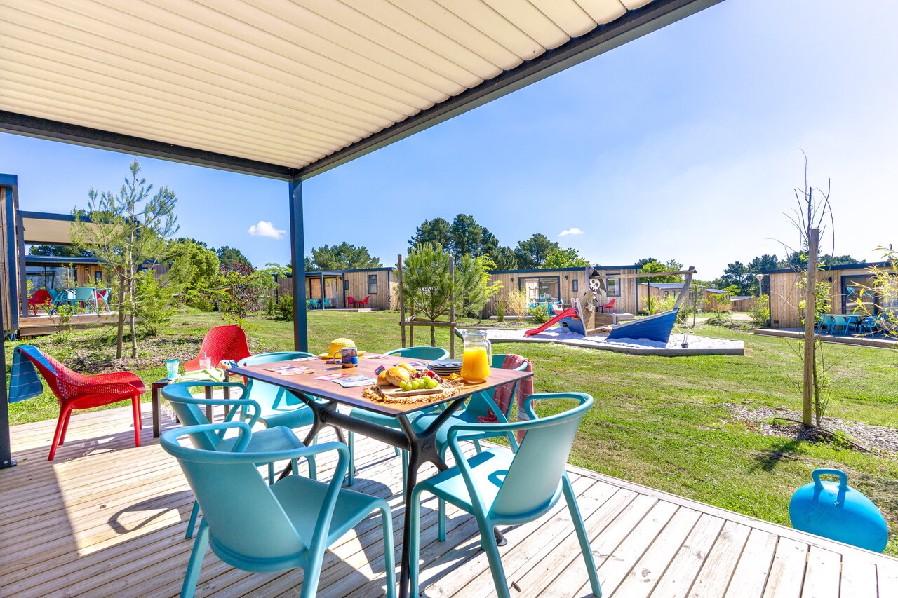 Terraza cubierta de mobil-home, zona de juegos infantiles en el camping CAPFUN Lac de Ribou en Cholet (49).
