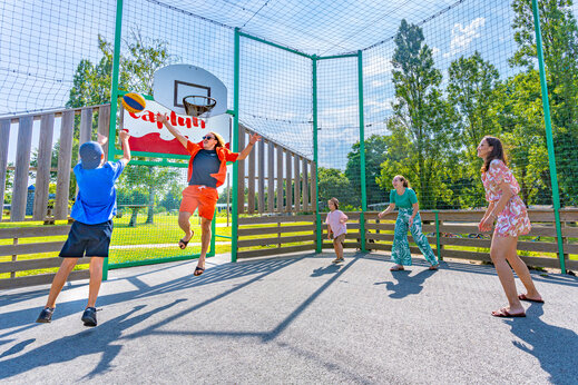Campo multideporte y familia jugando baloncesto en camping CAPFUN Lac de Ribou en Cholet (49).