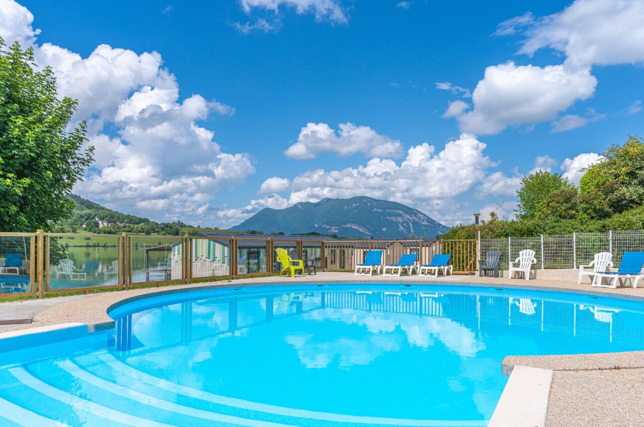 Piscina, tumbonas, lago y monta�as en el camping CLICOCHIC Lac du Lit du Roi.