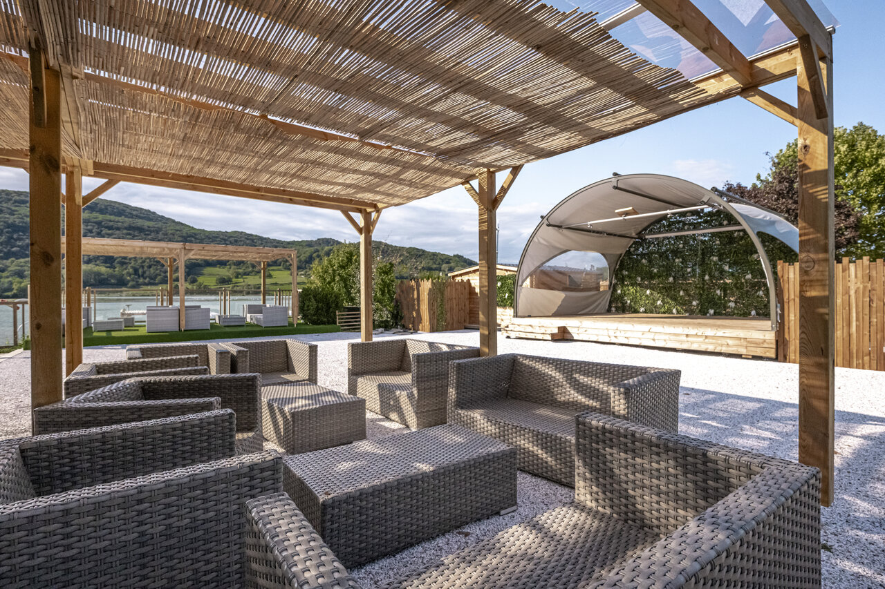 Lounge exterior, escenario, vista lago en el camping CLICOCHIC Lac du Lit du Roi en Massignieu-de-Rives (01).