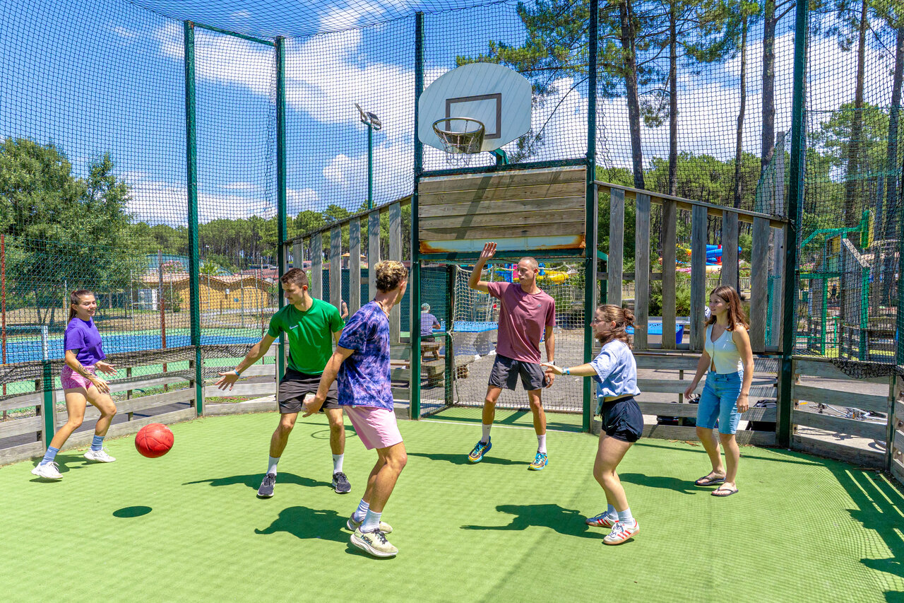 J�venes jugando baloncesto en la cancha multideporte del camping CAPFUN Landisland en Moliets-et-Maa.