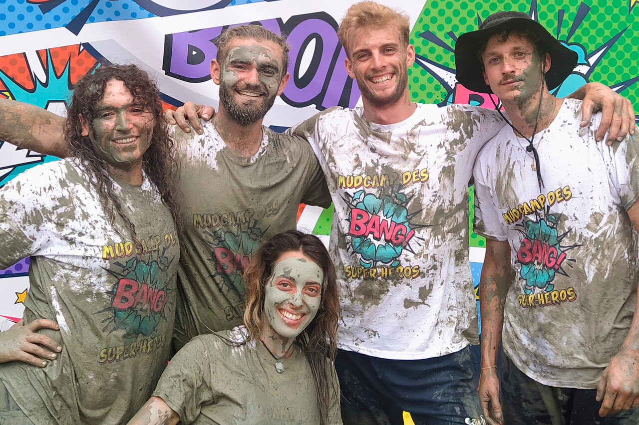 Amigos sonrientes cubiertos de barro tras Mudcamp en CAPFUN Landisland, Moliets-et-Maa (40).