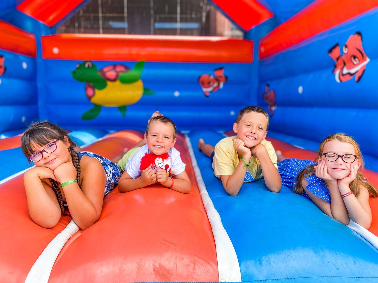 Cuatro ni�os sonrientes en un castillo hinchable colorido en el camping CAPFUN Landisland en Moliets-et-Maa.