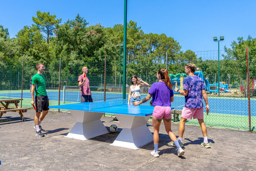 Amigos jugando ping-pong al aire libre en camping CAPFUN Landisland Moliets-et-Maa.