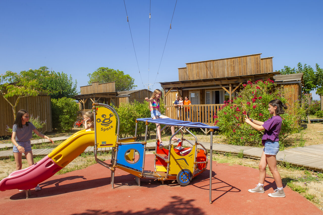 �rea de juegos con tobog�n y ni�os, cerca de chalets, camping CAPFUN Las Bousigues.