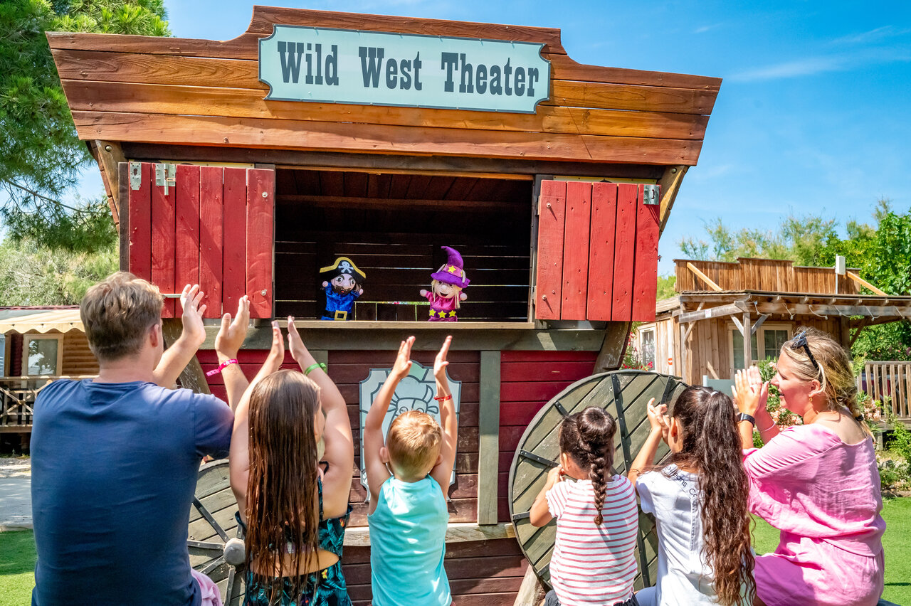 Espect�culo de marionetas en el Wild West Theater, familia aplaudiendo en el camping CAPFUN Las Bousigues en Le Barcar�s (66).