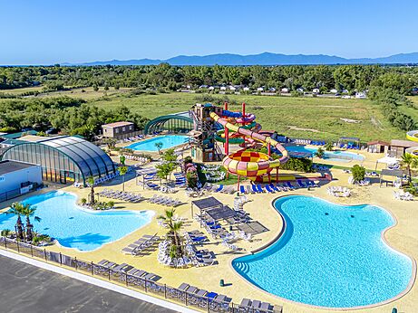 Toboganes acuáticos coloridos y piscinas exteriores en el camping CAPFUN Las Bousigues en Le Barcarès (66).