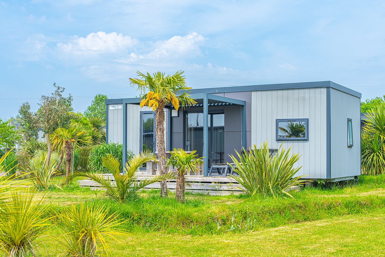 Moderno mobile home con terraza amueblada y palmeras en el camping VAGUES OCEANES Les Iles en Hudimesnil (50).