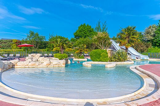 Piscina exterior, toboganes y sillas en camping VAGUES OCEANES Les Iles, Hudimesnil (50).