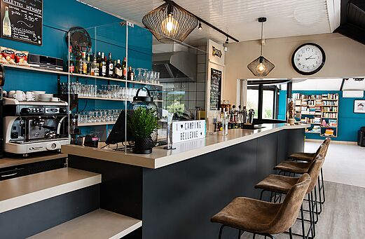Bar moderno, mostrador, cafetera y taburetes en el camping CLICOCHIC Bellevue.