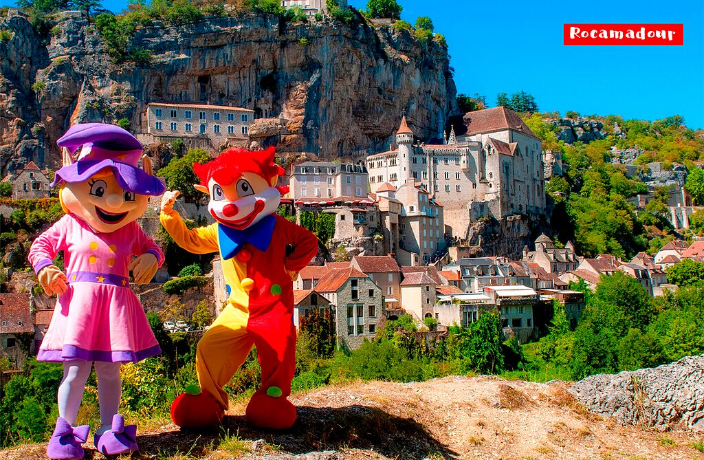 Mascotas sonrientes frente al pueblo medieval de Rocamadour, sitio tur�stico en Lot.