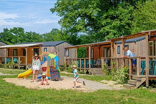 Mobil-homes de madera y zona de juegos en el camping CLICOCHIC Les Secrets de Padirac (46).
