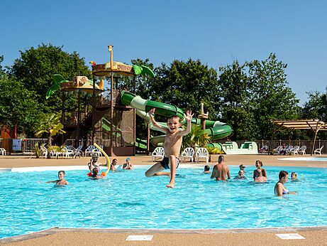Ni�o saltando en piscina con toboganes en camping CLICOCHIC Les Secrets de Padirac.