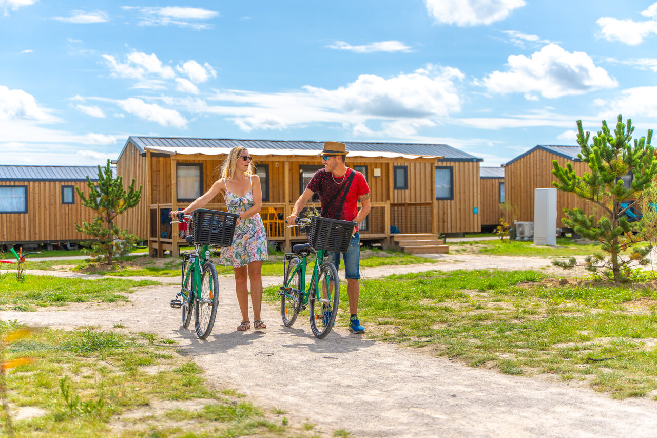 Pareja con bicicletas, casas m�viles modernas, camping VAGUES OCEANES Licorne, Dunkerque (59).