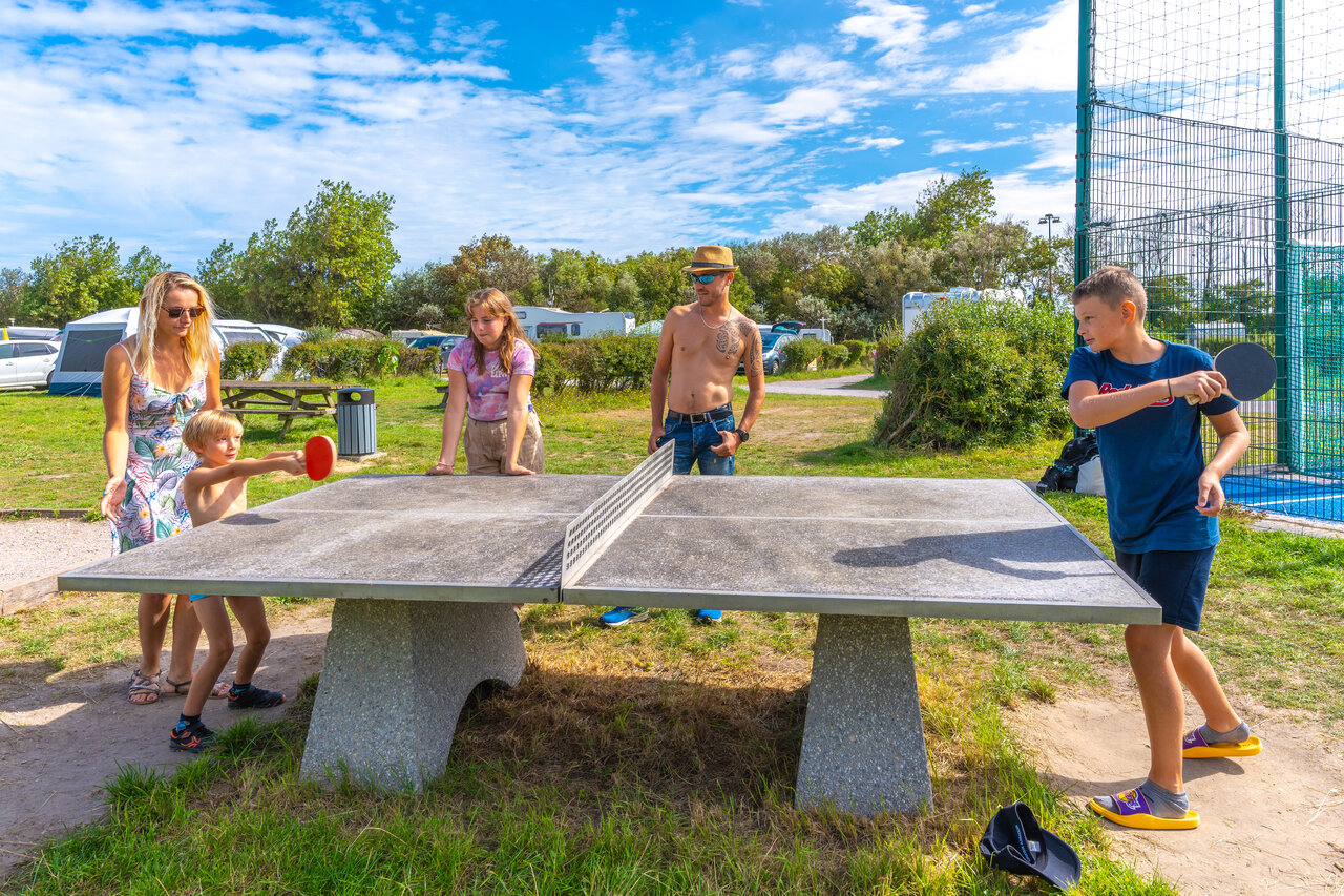 Familia jugando al tenis de mesa exterior en camping VAGUES OCEANES Licorne Dunkerque.