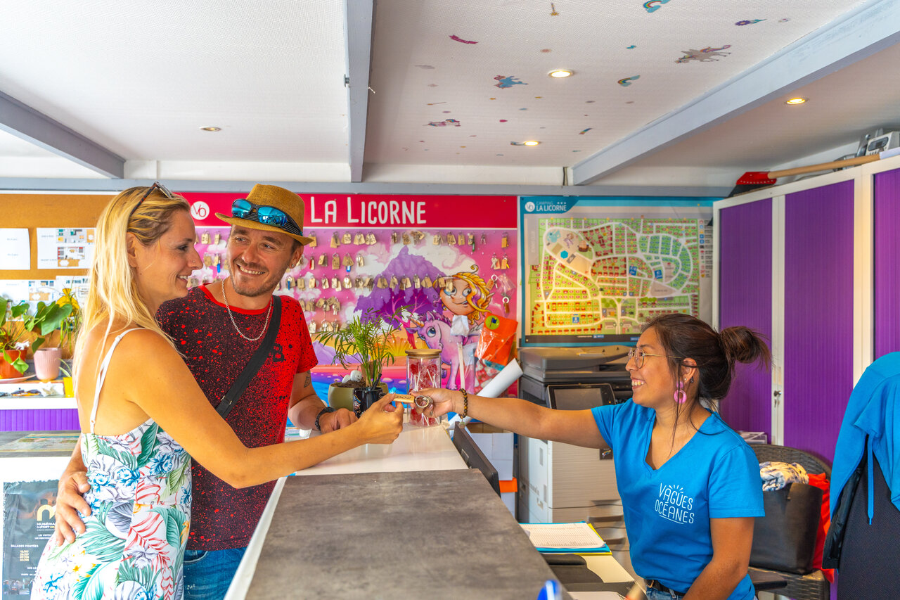 Pareja recibiendo llaves en la recepci�n del camping VAGUES OCEANES Licorne.