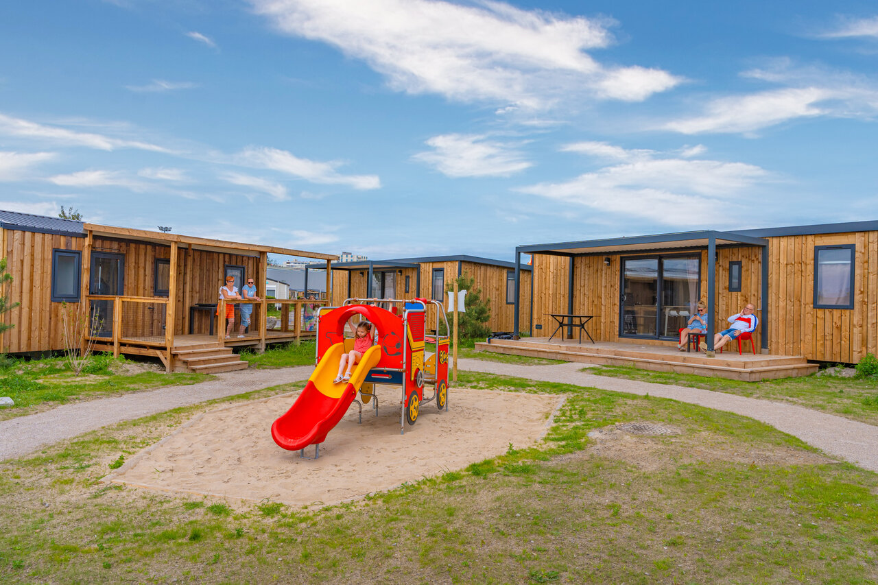 Zona de juegos con tobog�n y casas m�viles modernas en el camping VAGUES OCEANES Licorne en Dunkerque (59).