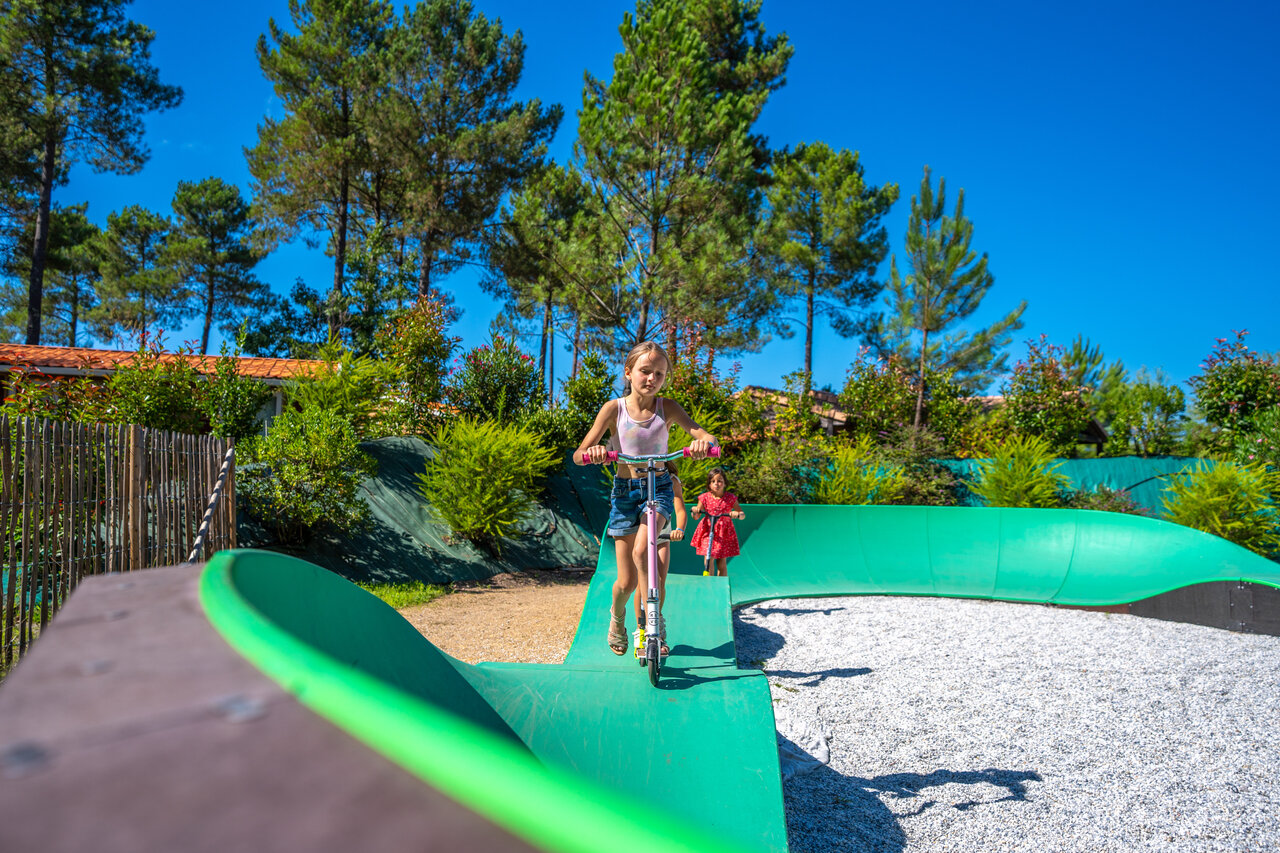Ni�as en patinetes en pista de patinaje verde en el camping CAPFUN Lila en LINXE (40).