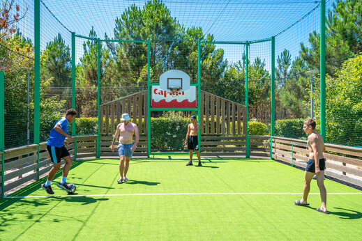 Cancha multideporte con gente jugando fútbol en el camping CAPFUN Lila en LINXE (40).