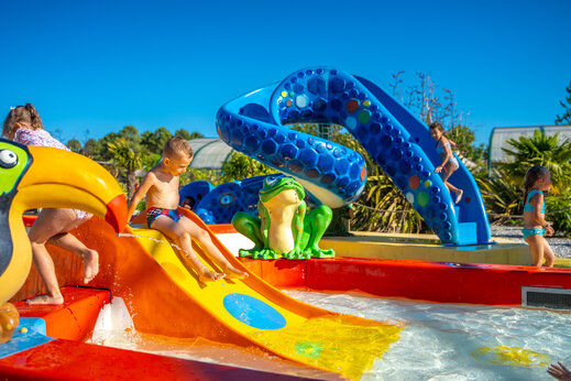 �rea de juegos acu�ticos con toboganes coloridos para ni�os en el camping CAPFUN Lila en LINXE (40).