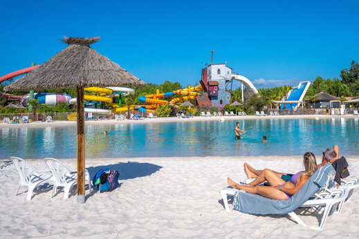 Piscina laguna, toboganes acu�ticos y sombrilla en el camping CAPFUN Lila en LINXE (40).
