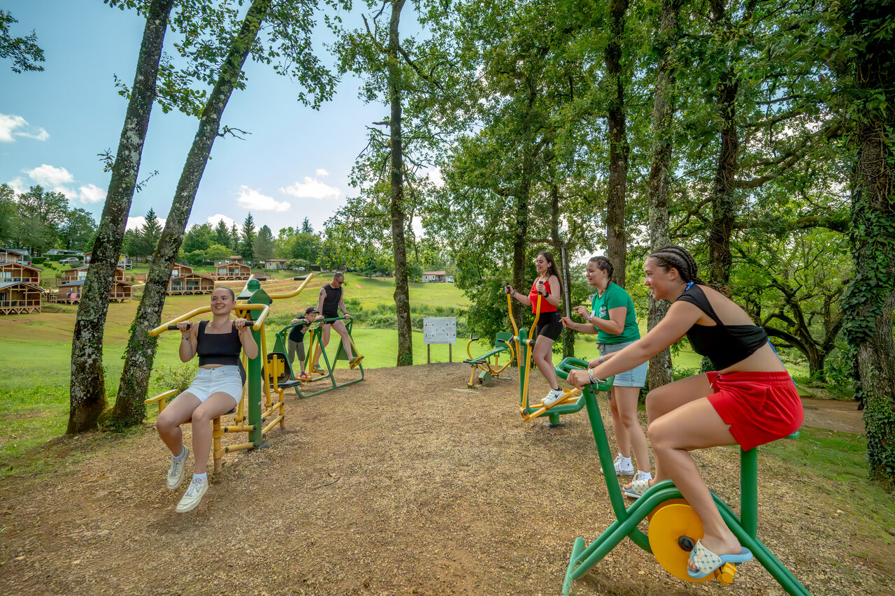 Equipos fitness exterior con campistas activos en el camping CLICOCHIC Linotte, Le Bugue (24).