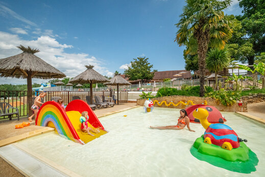 Piscina infantil, tobogán arcoíris y juegos acuáticos en CLICOCHIC Linotte Le Bugue.
