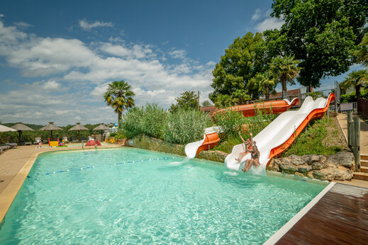 Piscina exterior con toboganes acuáticos en el camping CLICOCHIC Linotte en Le Bugue (24).