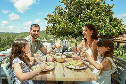 Familia almorzando en el restaurante del camping CLICOCHIC Linotte en Le Bugue (24).