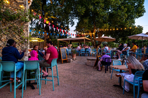 Terraza de restaurante y bar animada por la noche en el camping CLICOCHIC Linotte en Le Bugue.
