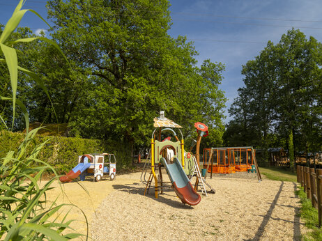 Zona de juegos infantil, toboganes y trampolín en el camping CLICOCHIC Linotte en Le Bugue.
