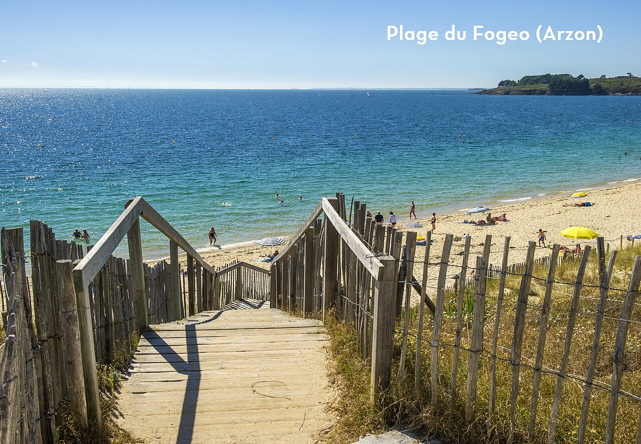 Playa del Fogeo en Arzon, Morbihan, con acceso de madera y mar turquesa.