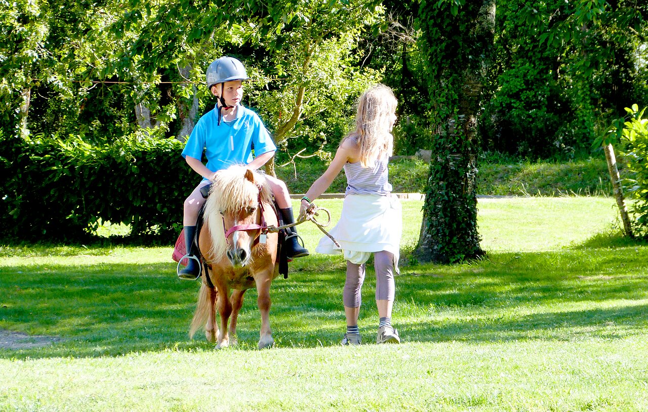 Ni�o a caballo pony, guiado por monitora en camping CAPFUN Lodge en SARZEAU (56)
