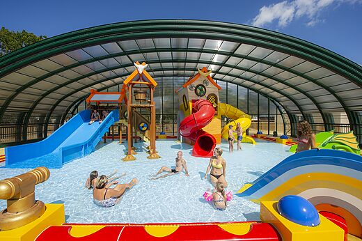 Piscina cubierta con toboganes y juegos en el camping CAPFUN Lodge en SARZEAU (56).