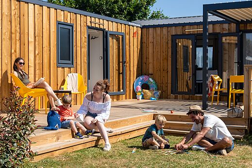 Mobil-home moderno de madera con terraza, familia en camping CAPFUN Lodge SARZEAU (56).