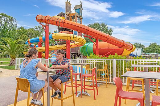 Toboganes acu�ticos coloridos y terraza de bar exterior en el camping CAPFUN Lodge en SARZEAU (56).