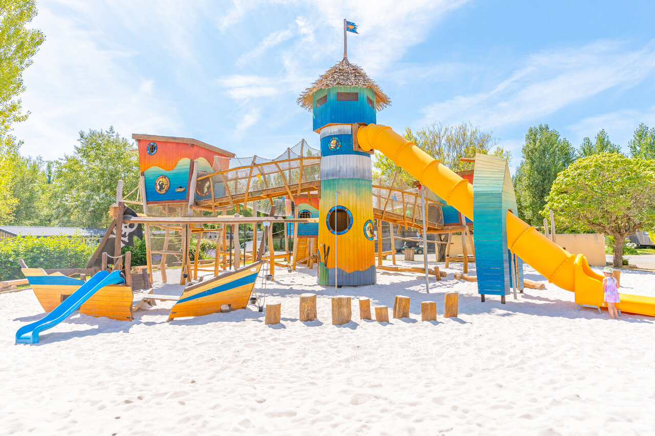Parque infantil pirata con toboganes y arena en el camping CAPFUN Loubine en Les Sables d'Olonne.