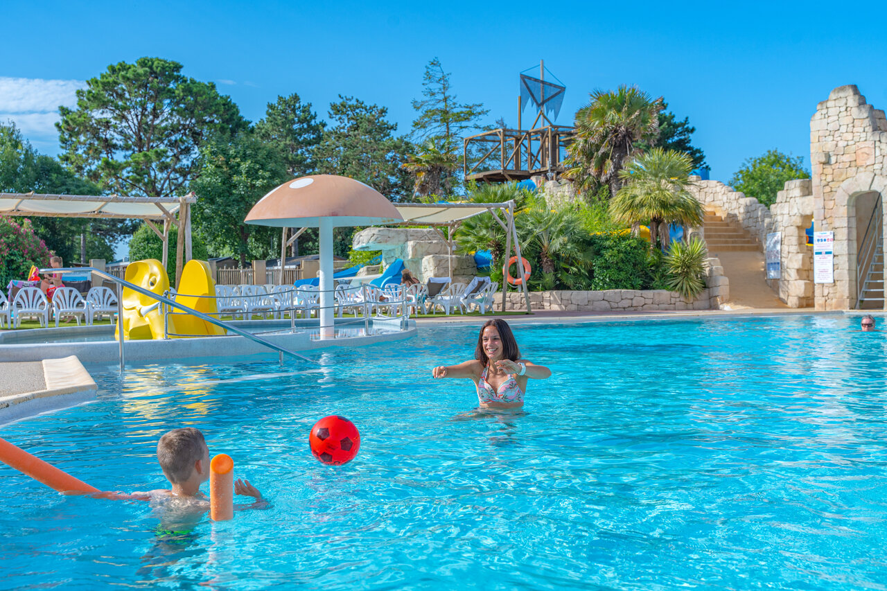 Piscina exterior con toboganes, juegos acu�ticos y ni�os jugando en el camping CAPFUN Loubine en Les Sables d'Olonne (85).