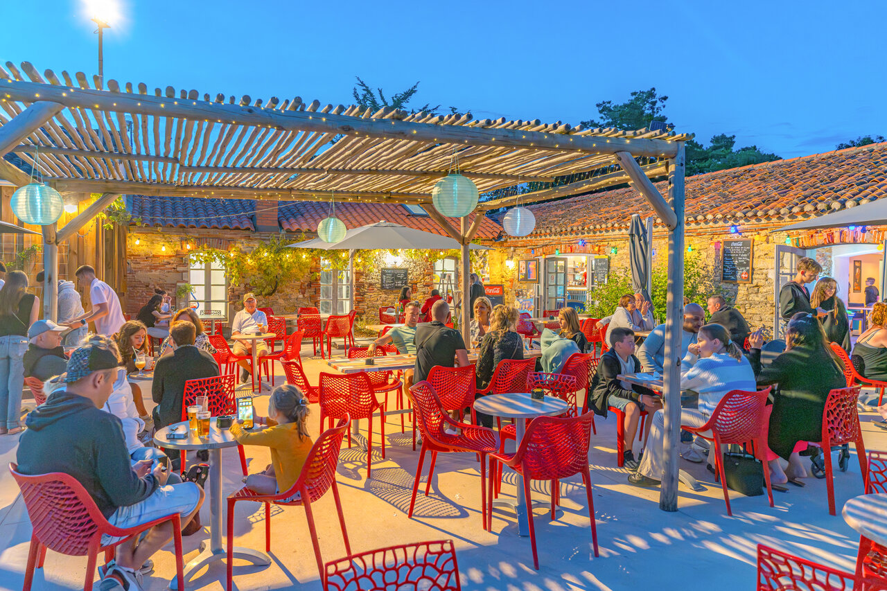 Terraza de restaurante-bar animada, p�rgola iluminada, camping CAPFUN Loubine Les Sables d'Olonne.