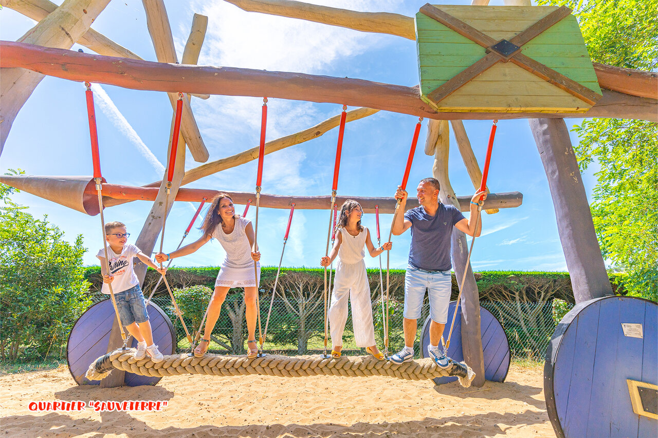 Familia divirti�ndose en estructura de juegos de madera en camping CAPFUN Loubine en Les Sables d'Olonne.
