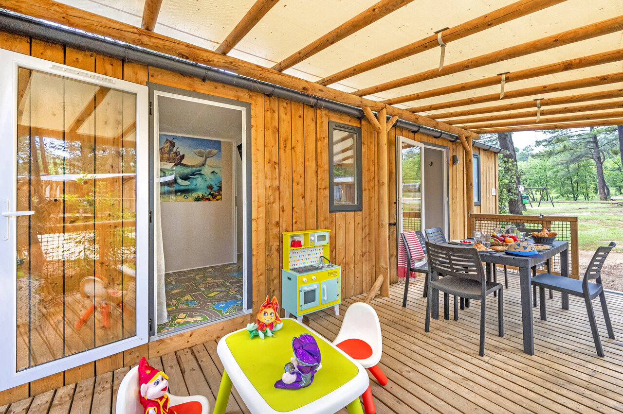 Terraza mobil-home, comedor exterior, juegos infantiles. Camping CLICOCHIC Lou Cantaire en FAYENCE.