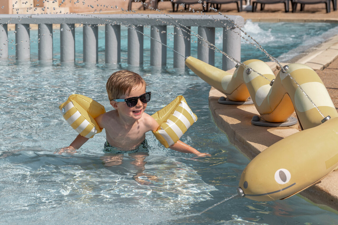 Ni�o sonriente con manguitos, juegos de agua piscina camping CLICOCHIC Lou Cantaire Fayence.