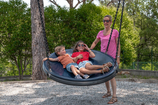 Ni�os en columpio, zona de juegos en el camping CLICOCHIC Lou Cantaire en FAYENCE.