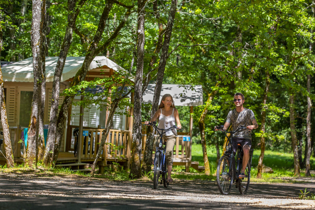 Pareja en bicicleta por un sendero, mobil-homes en el camping CLICOCHIC Lou Castel.
