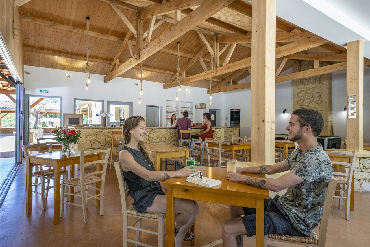 Bar y restaurante interiores modernos en el camping CLICOCHIC Lou Castel en Castelnaud-la-Chapelle (24).