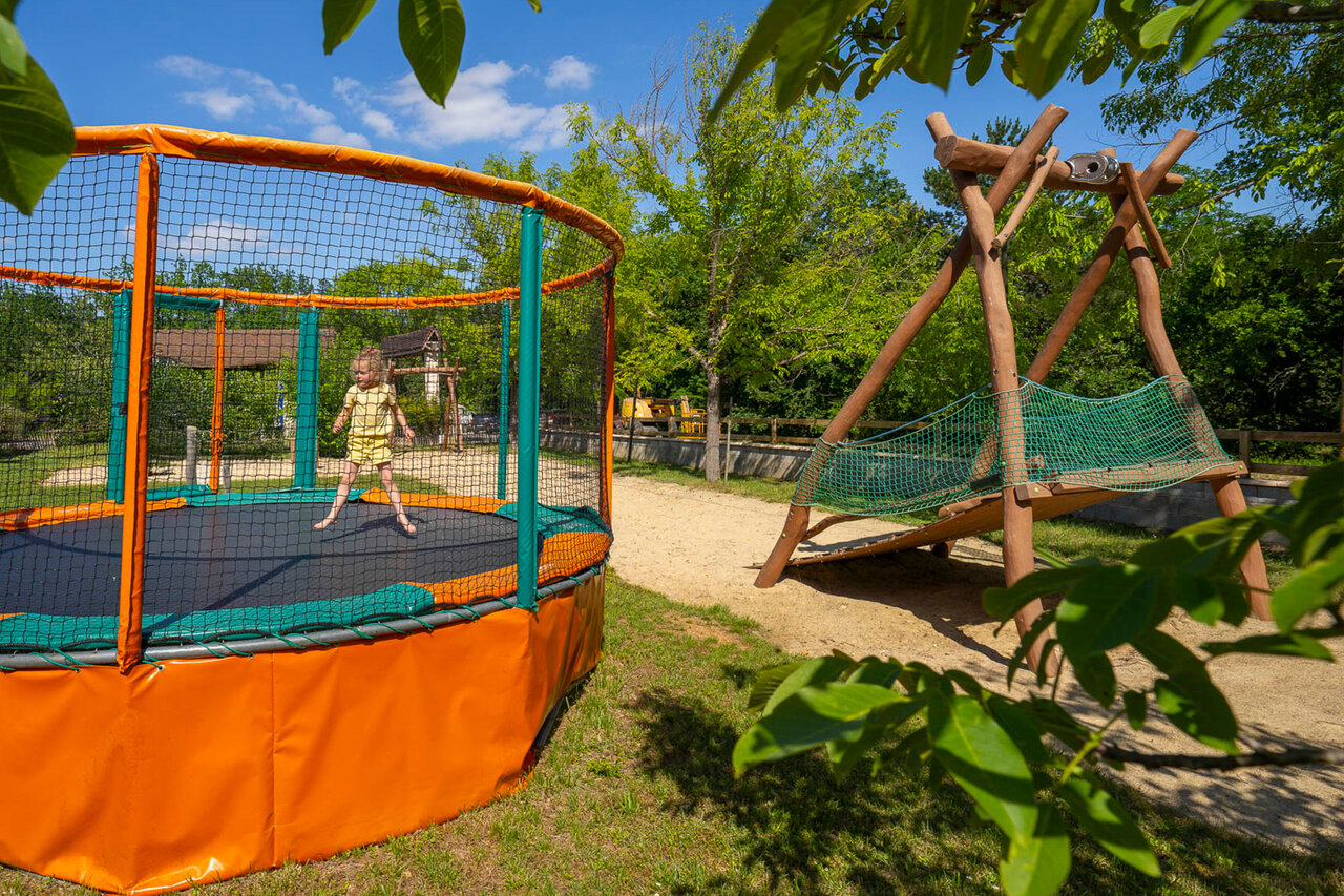 Trampol�n, zona de juegos en el camping CLICOCHIC Lou Castel en Castelnaud-la-Chapelle (24).