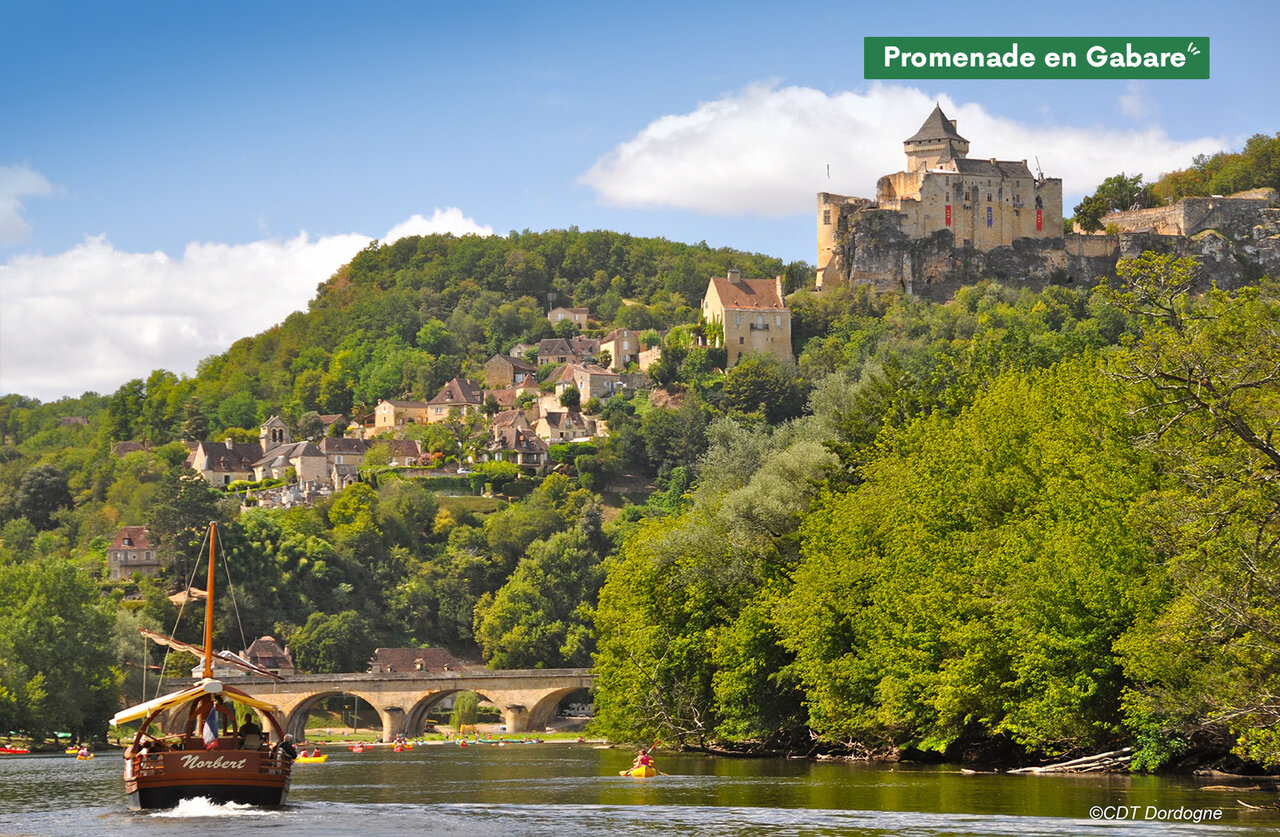 Gabarra, kayaks, castillo y pueblo en el camping CLICOCHIC Lou Castel en Castelnaud-la-Chapelle.